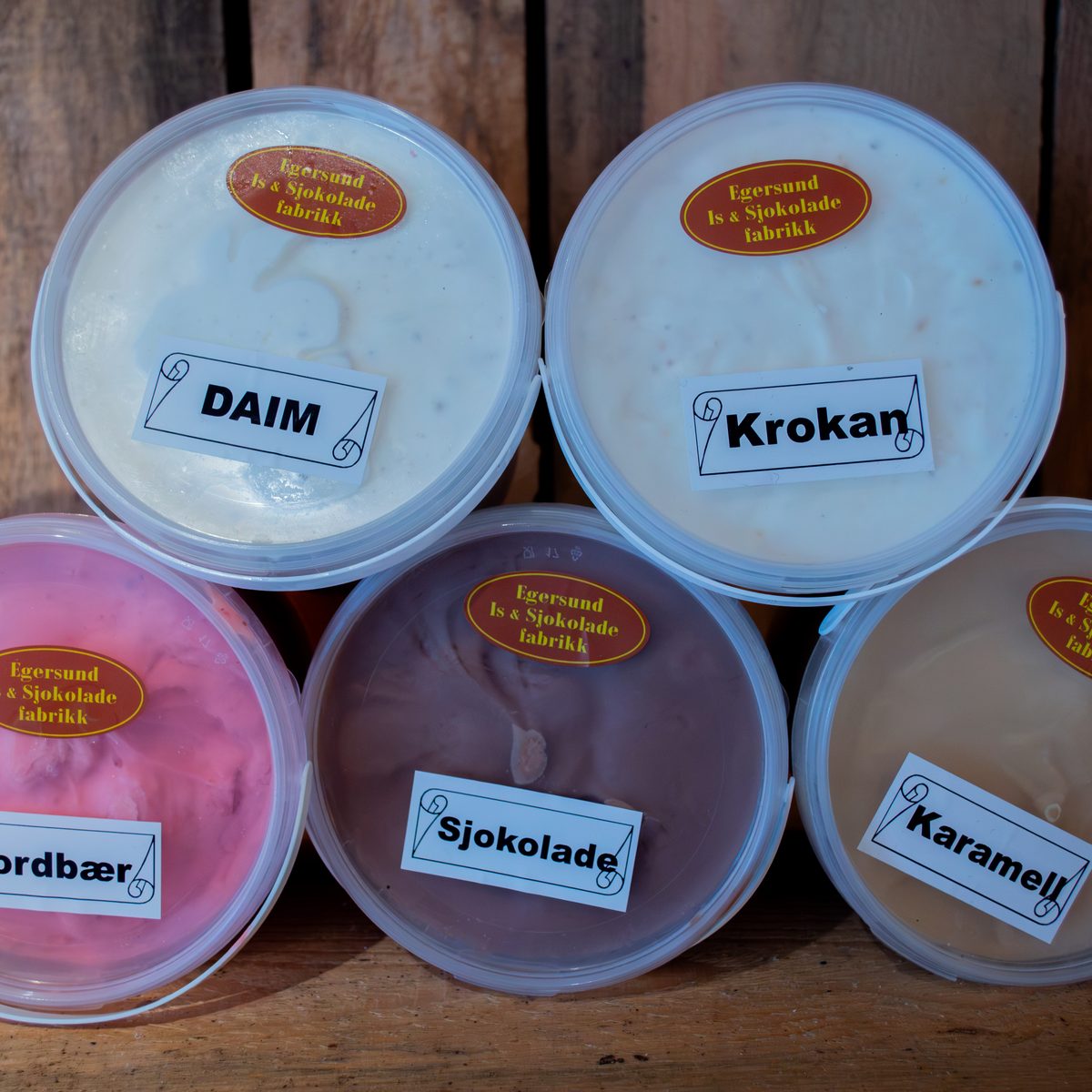 Nærbilde av iskrembeger fra Hole Gardsutsalg – DAIM, Krokan, jordbær, sjokolade og karamell.